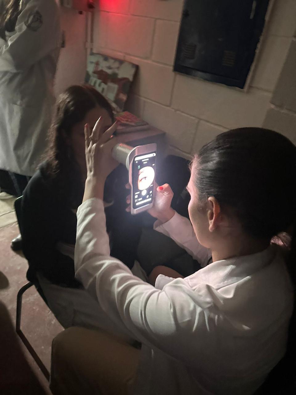 Jovem sendo examinado com o Eyer em escola durante o projeto Enxergando o Futuro.